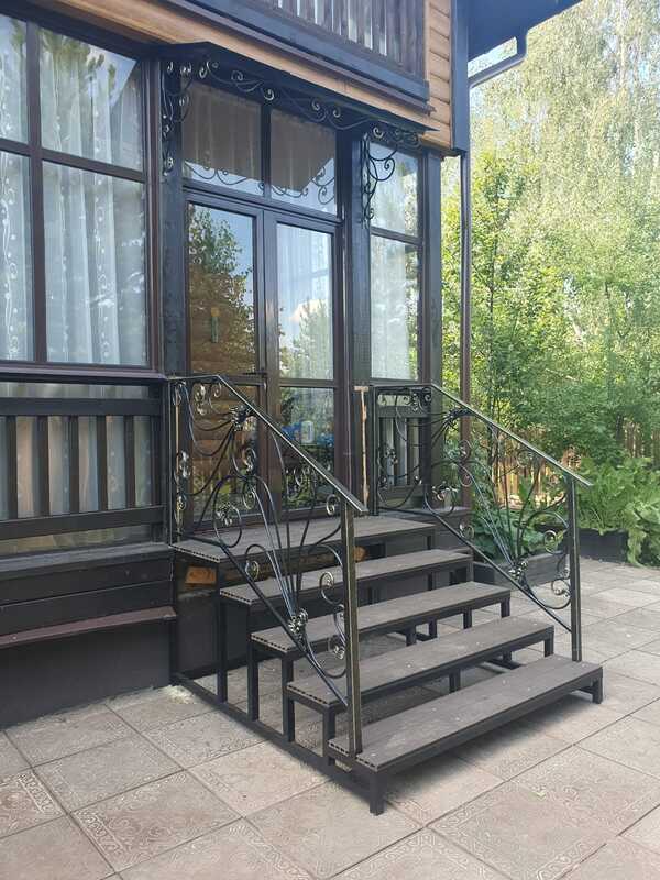 Кованые перила и козырёк для крыльца деревянного дома
