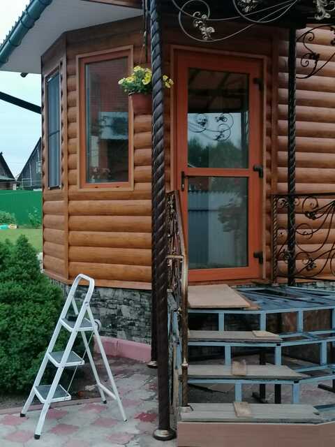 Кованое крыльцо с угловой лестницей и козырьком для бревенчатого дома