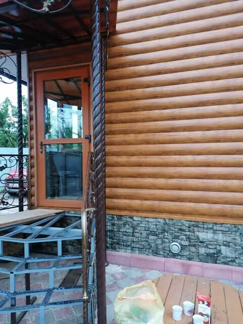 Кованое крыльцо с угловой лестницей и козырьком для бревенчатого дома