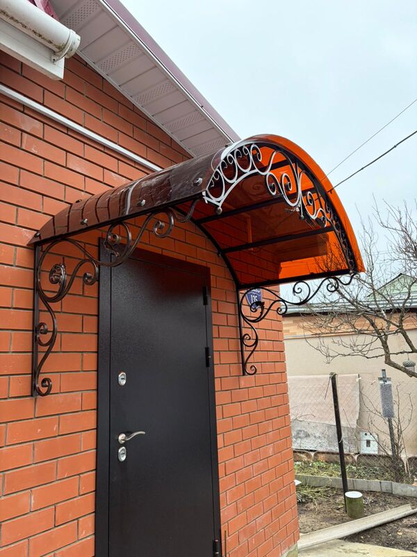 Арочный кованый козырёк с оранжевым поликарбонатом